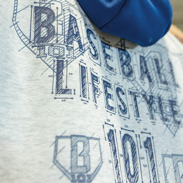 Close up of person wearing a gray hoodie with blue hood with a blue BL101 logop of