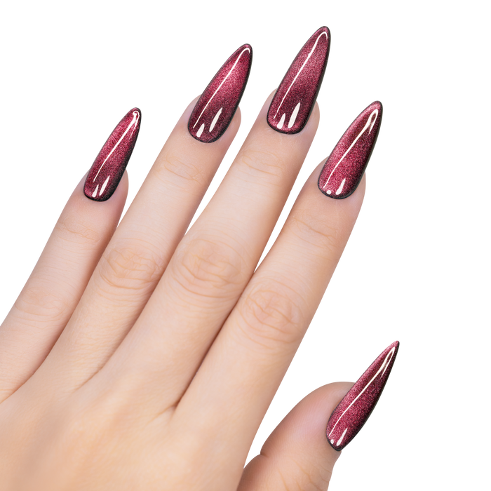 Hand with stiletto nails painted in a pink glittery nail polish on a white background