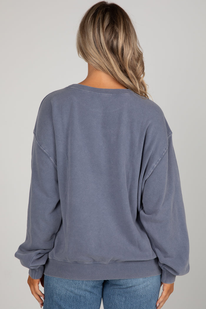 Person wearing a blue sweatshirt and jeans on a plain background