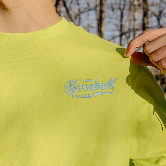 Person wearing a bright green sweatshirt with 'Baseball Lifestyle 101' logo on the chest, outdoors.