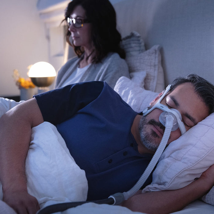 Man in bed wearing Airlift N30i CPAP Mask while woman is next to him