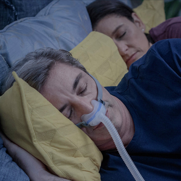 Man sleeping in bed while wearing Airlift N30 CPAP Mask