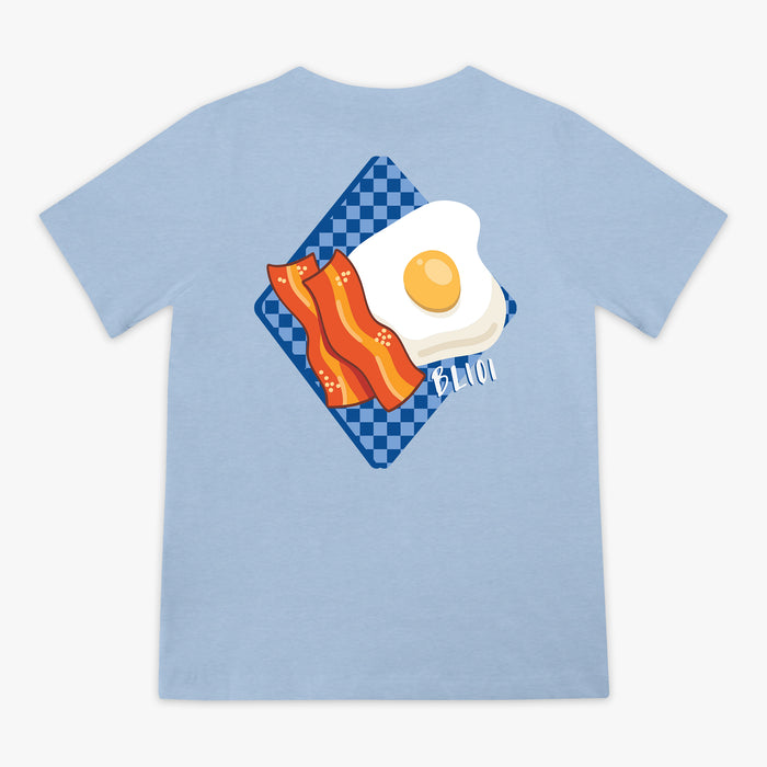Light blue t-shirt with a graphic of an egg and bacon on a checkered plate.