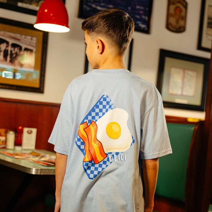 Person wearing a t-shirt with a bacon and egg design in a diner