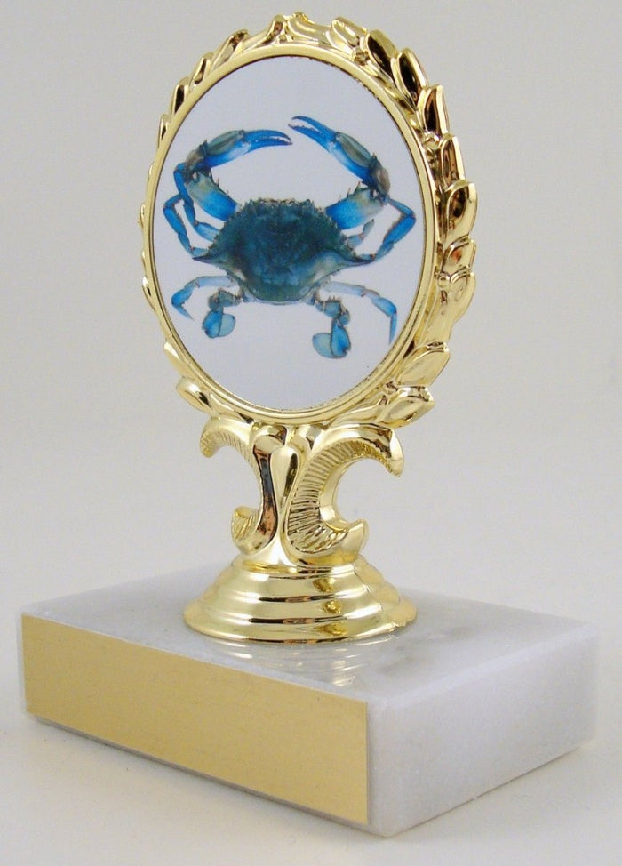 A trophy featuring a blue crab illustration on a gold-colored mount with a white marble base.
