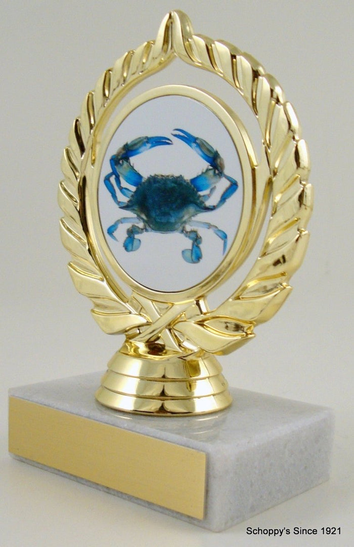 A trophy featuring a blue crab illustration on a gold-colored mount with a white marble base.