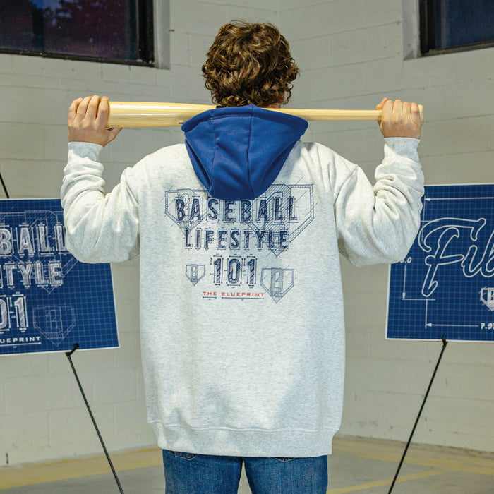 Person wearing a gray hoodie with blue hood with a blue an red BL101 logo