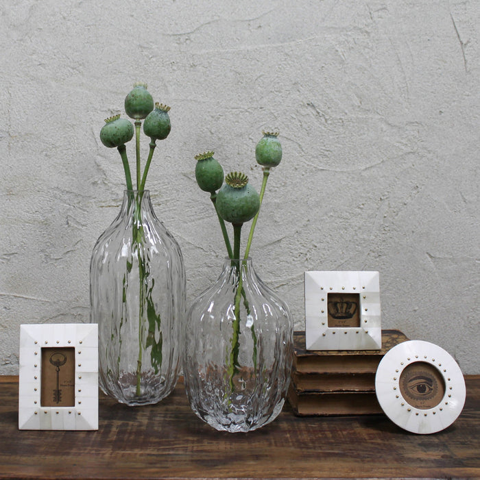 Rectangular bone photo frame with brass rivets on shelf display, cream white.