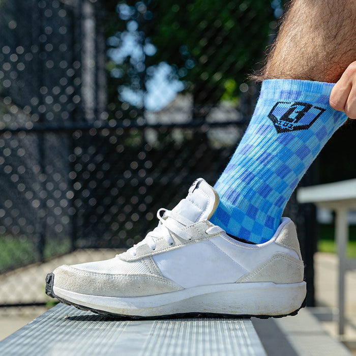 Adult model wearing multi-color socks with "Checker Print Performance  3-Pack" design