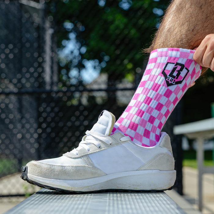 Adult model wearing multi-color socks with "Checker Print Performance  3-Pack" design
