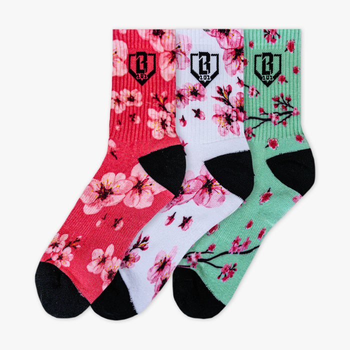 Adult model wearing multi-color socks with "Cherry Blossoms Performance  3-Pack" design