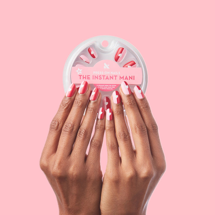 Colorblock Heart - Press-On | Short | Round hands with short round false nails featuring glossy pink and white heart designs on pink background