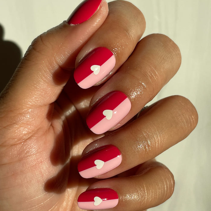 Colorblock Heart - Press-On | Short | Round hand with short round false nails featuring pink and red half-block design with white heart details