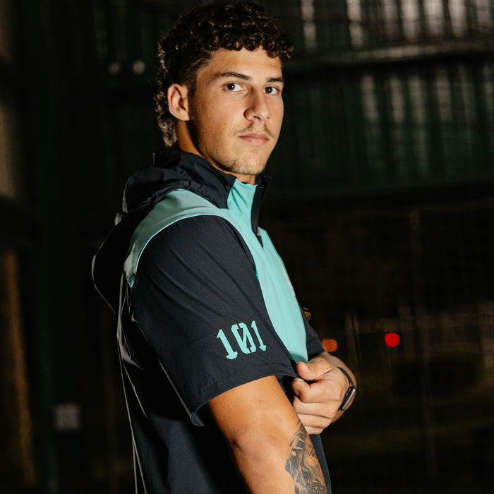 Adult model wearing black and teal Diamond Tech Pro Cage Jacket jacket