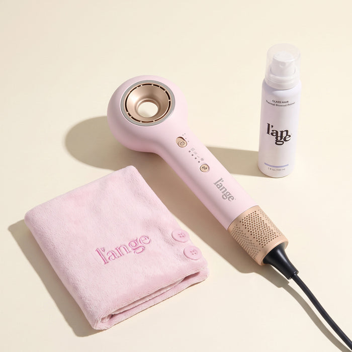 L'ange pink Axia HaloRing hair dryer, blush microfiber towel, Glass Hair Thermal Blowout Primer on a beige background.