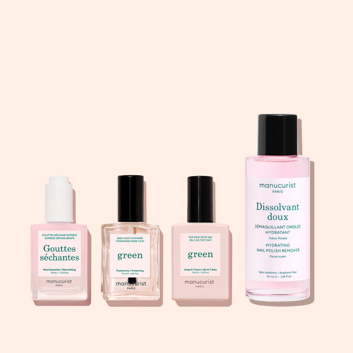 Four manicure products in clear bottles with black caps are lined up on a light pink background. The labels read: Manucurist Drying Drops, featuring fast-drying drops, and Green (two bottles) for a gentle Green manicure, alongside Doux Dissolvant.