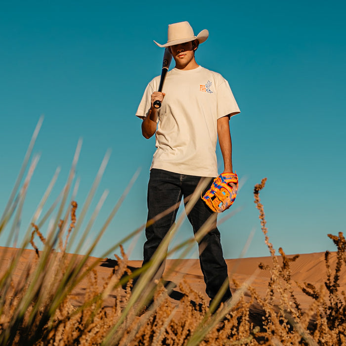 Adult model wearing white graphic tee with “Dust Don't Settle Relaxed” design