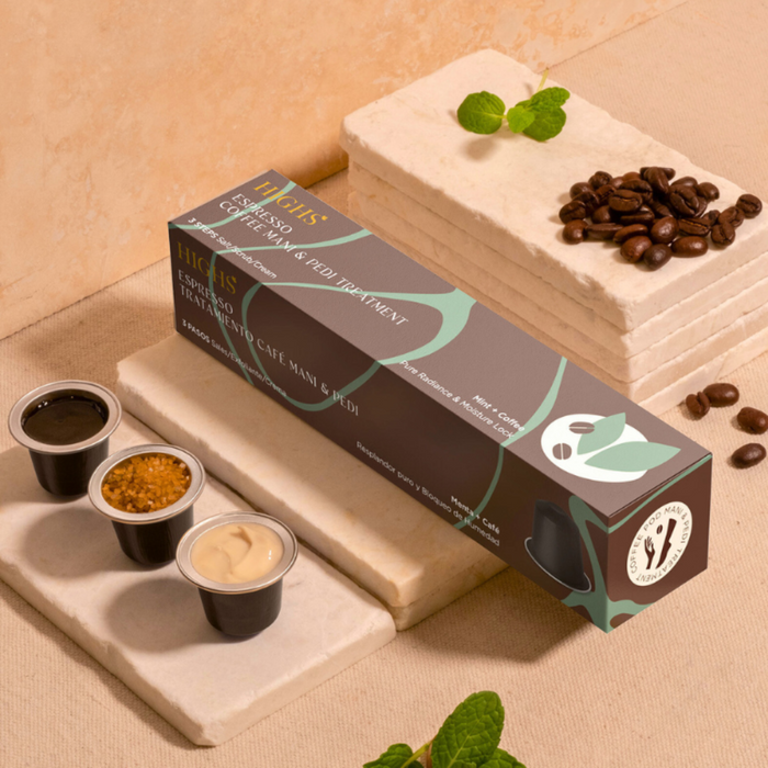 A packaged spa product called 'Espresso Coffee Mani & Pedi Treatment' with coffee-themed packaging, displayed on a stone surface with a cup of coffee and mint leaves in the background, indicating a coffee and mint flavored foot and hand treatment.