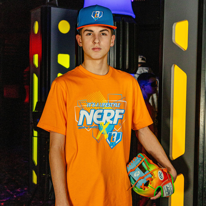 Person wearing an orange 'NERF X BL101' t-shirt and BL101 blue cap, holding a colorful baseball glove, in front of a vibrant, multicolored background.