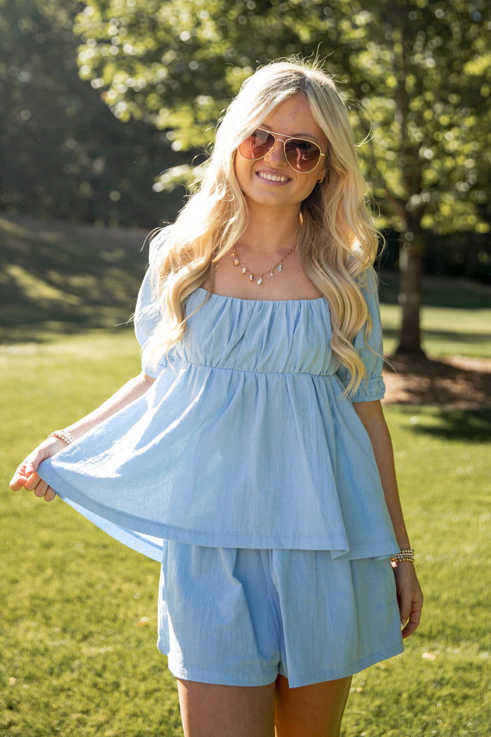 Woman wearing a light blue dress in a park setting