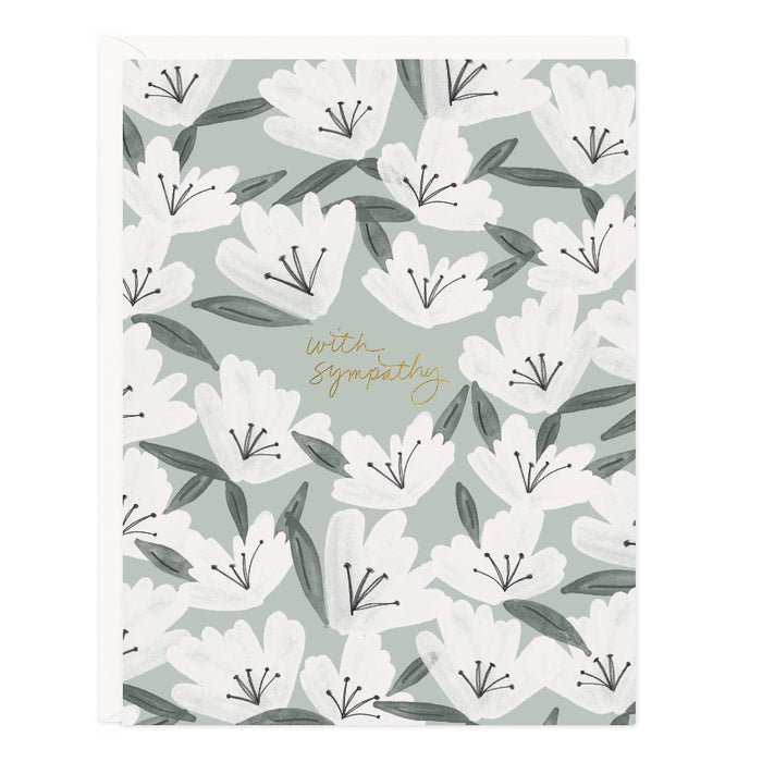 A floral sympathy card with white flowers and green leaves on a light background, with the words 'with sympathy' written in gold foil.