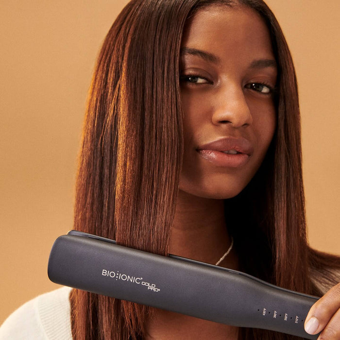 Woman with dark skin and dark hair using GoldPro styling iron.