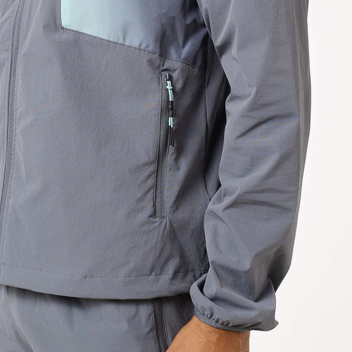 Close-up of the Gradient Motion Tracksuit jacket in Charcoal/Mint, highlighting the concealed zip pocket, mint-accented zip pull and elasticated cuff.