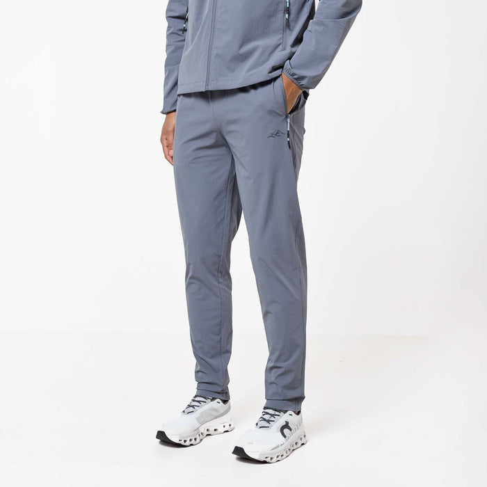 Close-up of the Gradient Motion Tracksuit pants in Charcoal/Mint, featuring a tapered fit, zipped side pocket with mint detailing and subtle Closure branding.