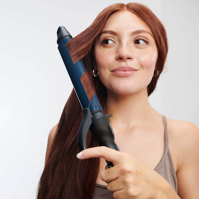 Woman with freckles and long read hair using Graphene MX® Long Barrel Curling Iron