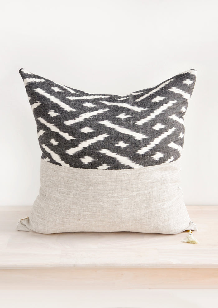 Square throw pillow in reversible design with contrasting black and white fabric on front and back