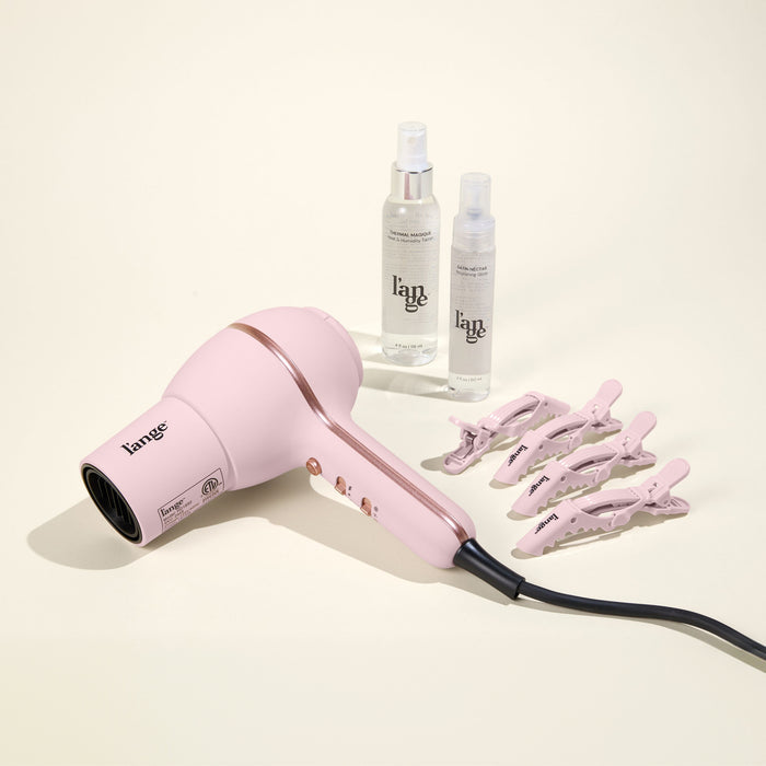 Hot Stuff Blowout Set, featuring a Blush Hot Stuff dryer, Alligator Clips, Thermal Magique, and Satin Nectar, displayed on a beige background