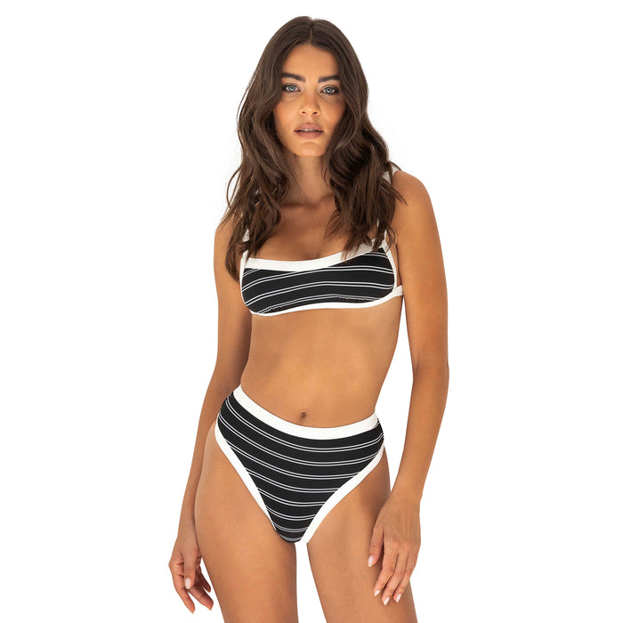 Woman wearing a black and white striped bikini on a white background