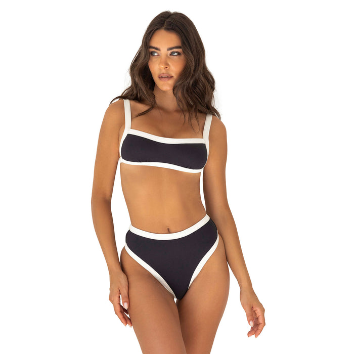 Woman wearing a black and white bikini on a white background