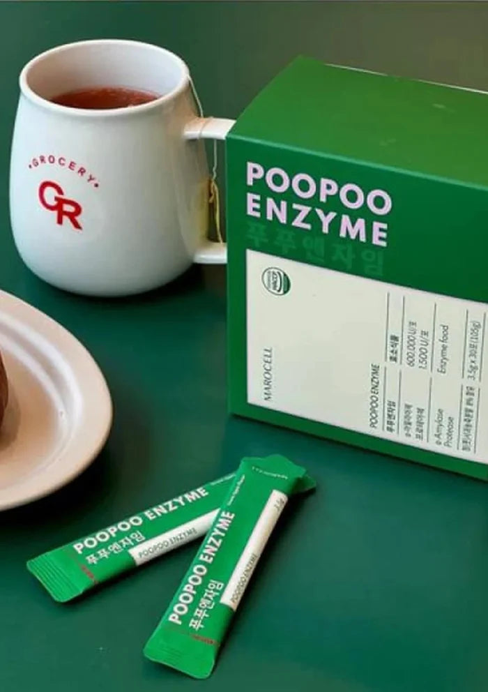 Green 'POOPOO ENZYME' packaging with tea bags on a green surface