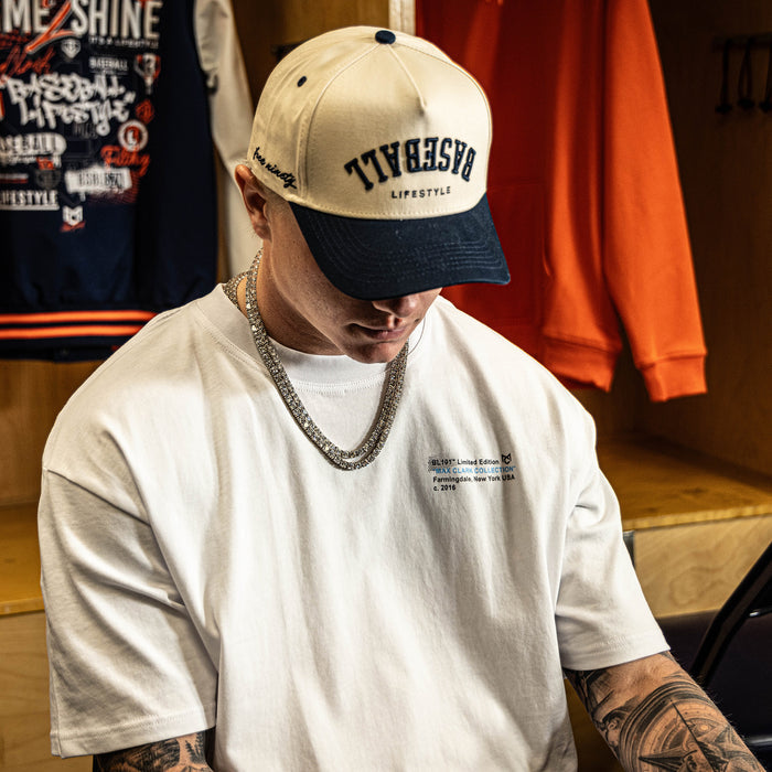 Person wearing a cap and white t-shirt in a locker room setting
