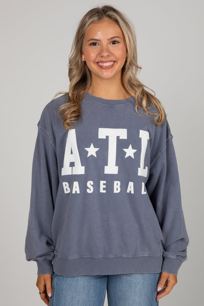 Woman wearing a blue sweatshirt with 'ATL Baseball' text on a gray background