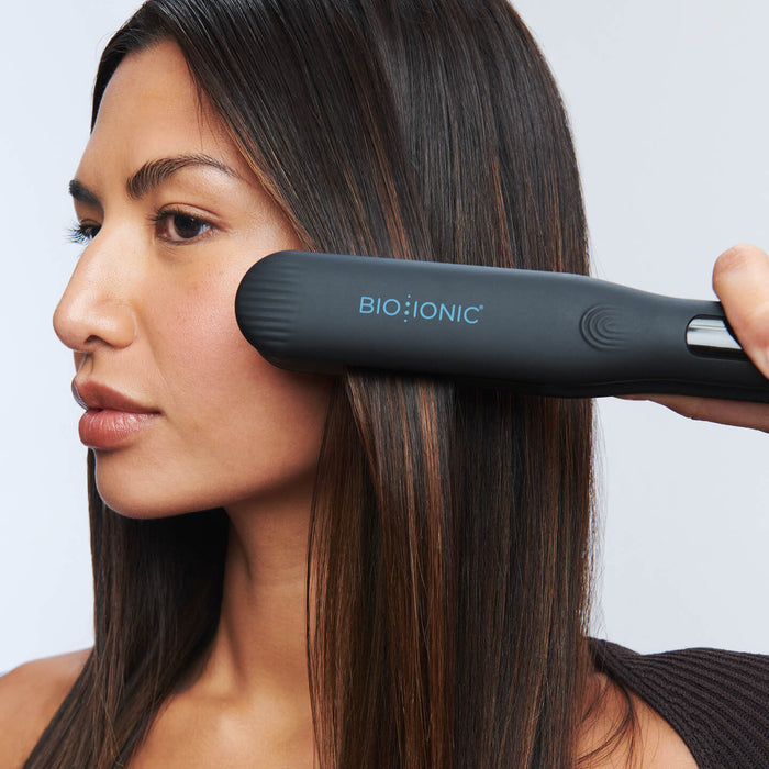 Woman using OnePass Styling Iron on long dark hair