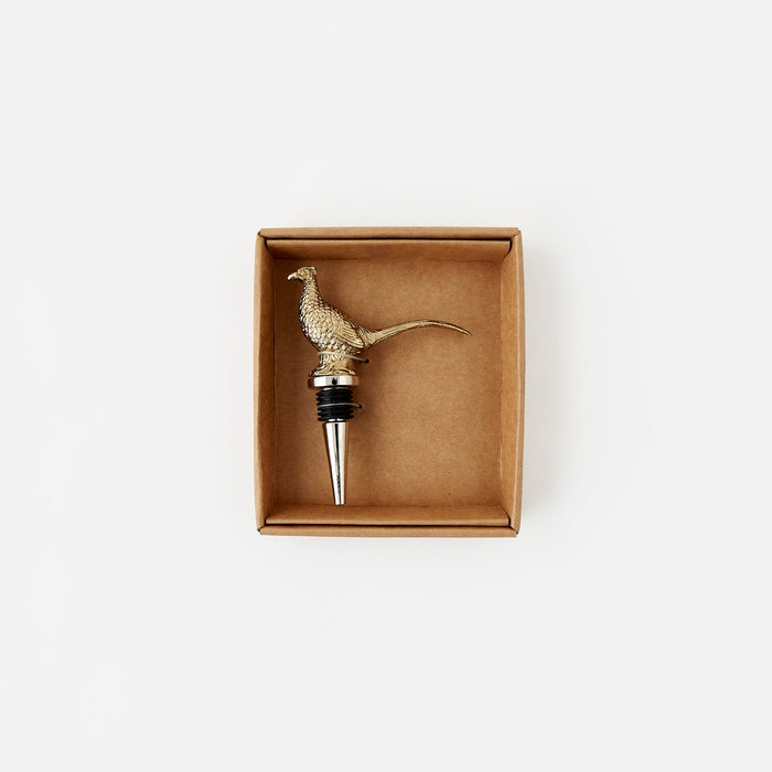 Brass pheasant-shaped bottle stopper in a cardboard box on a white background