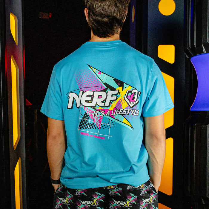 Person wearing a blue t-shirt with 'NERF' branding in front of colorful equipment.