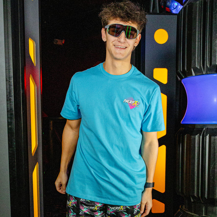 Person wearing a blue t-shirt with a 'NERF' logo in front of colorful background