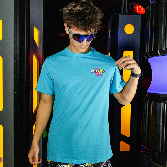 Person wearing a blue t-shirt with a colorful logo in front of a colorful, abstract background.