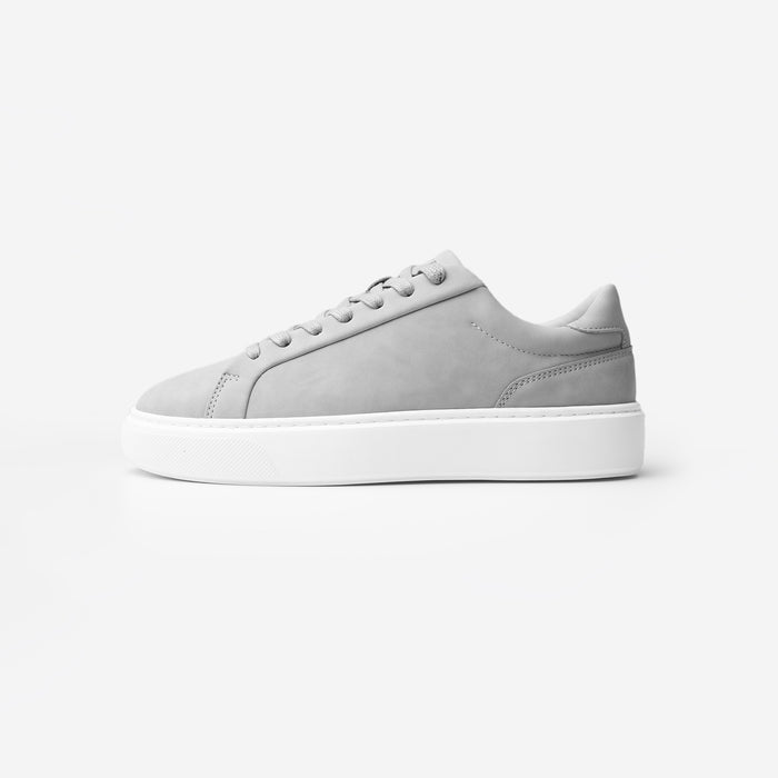 Side view of the Premium Classic Trainer in Grey, featuring a clean white PU upper, grey faux suede heel, white lace-up fastening and cushioned cup sole.