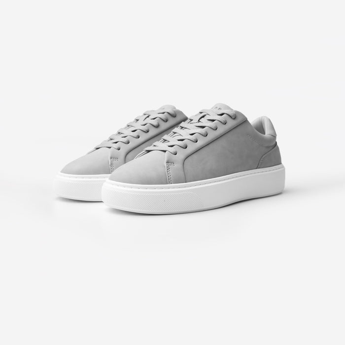 Three-quarter view of the Premium Classic Trainers in Grey, featuring clean white PU uppers, grey lace-up fastening, grey faux suede heel panels and cushioned cup soles.