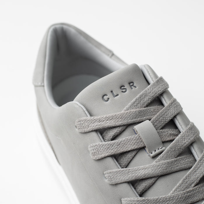 Close-up of the Premium Classic Trainer in grey, highlighting the grey textured laces, smooth PU upper and debossed CLSR tongue branding.