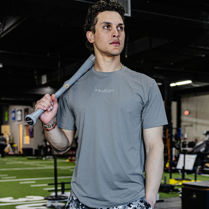 Man holding a baseball bat in a gym setting