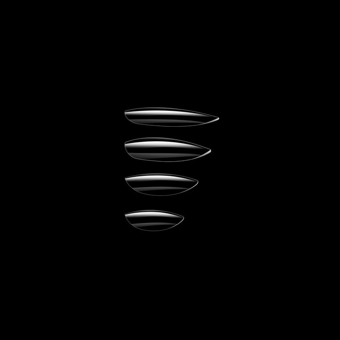 Set of four clear nail tips on a black background