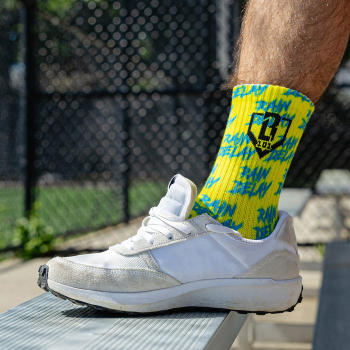 Adult model wearing multi-color socks with "Rain Delay Performance  3-Pack" design
