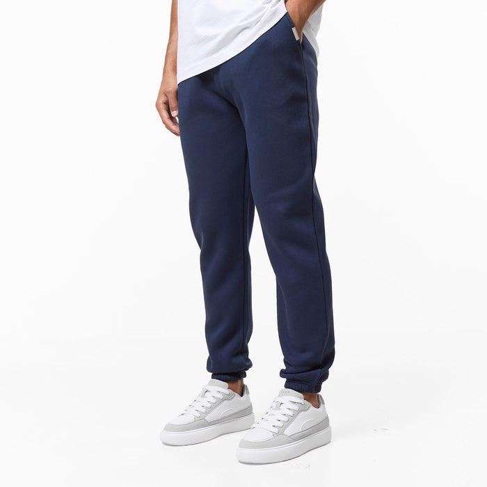 Mens navy cuffed tracksuit bottoms paired with white trainers