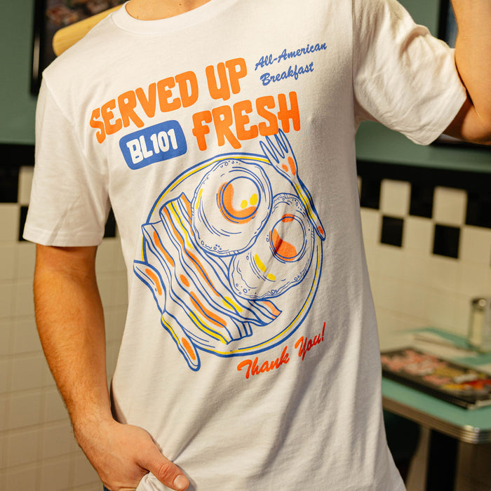 Close up of person wearing white t-shirt with a bacon and egg graphic and 'Served Up BL101 Fresh' text on a white background
