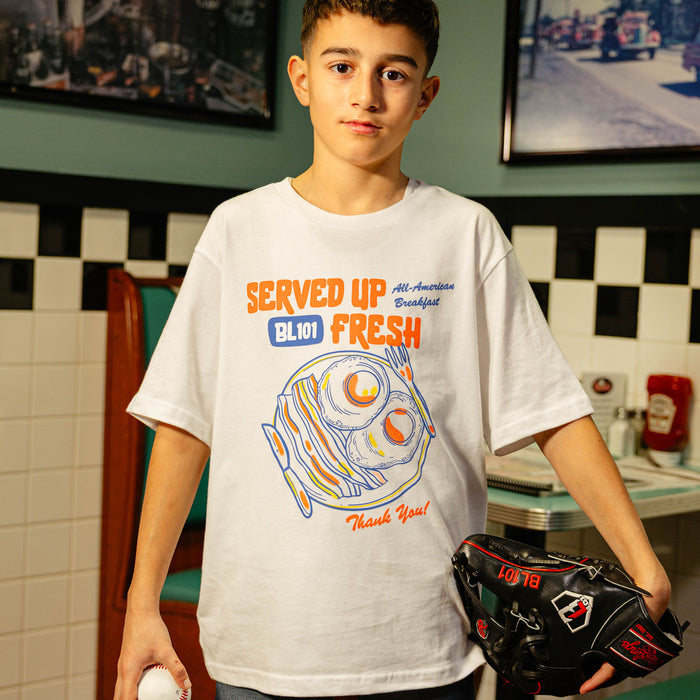Young boy wearing a white t-shirt with a bacon and egg graphic and 'Served Up BL101 Fresh' text
